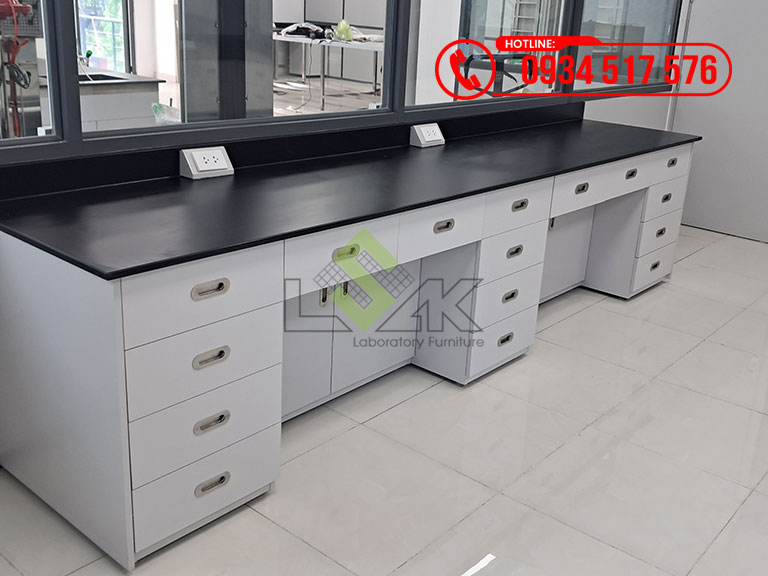 Bàn thí nghiệm áp tường mặt bàn sử dụng tấm phenolic dày 18mm chống hóa chất, hộc tủ kín, cánh tủ thụt vào 20cm để ngồi thao tác