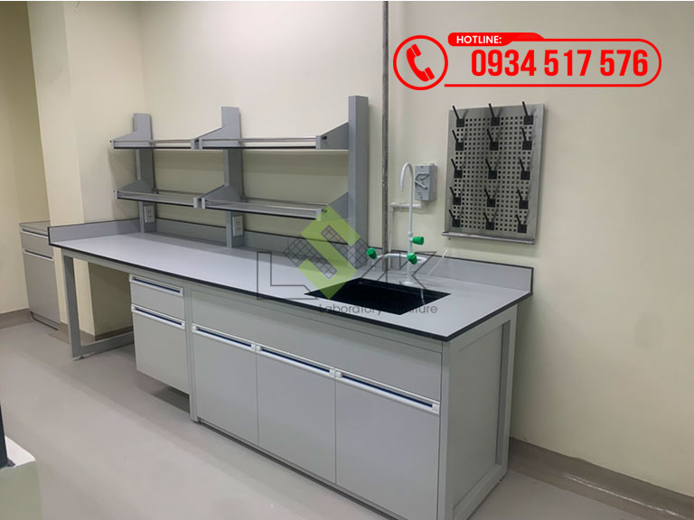 Bàn thí nghiệm áp tường có kệ để hóa chất, có bồn rửa tay, vòi rửa, có giá phơi dụng cụ